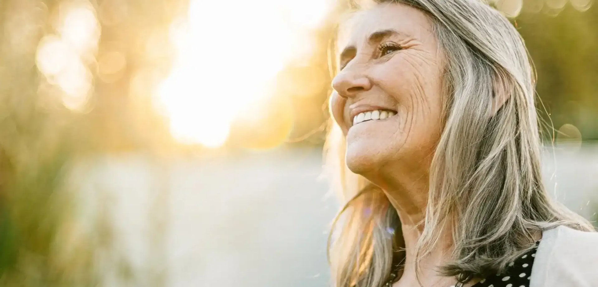 Eine Frau mit grauen Haaren lächelt.